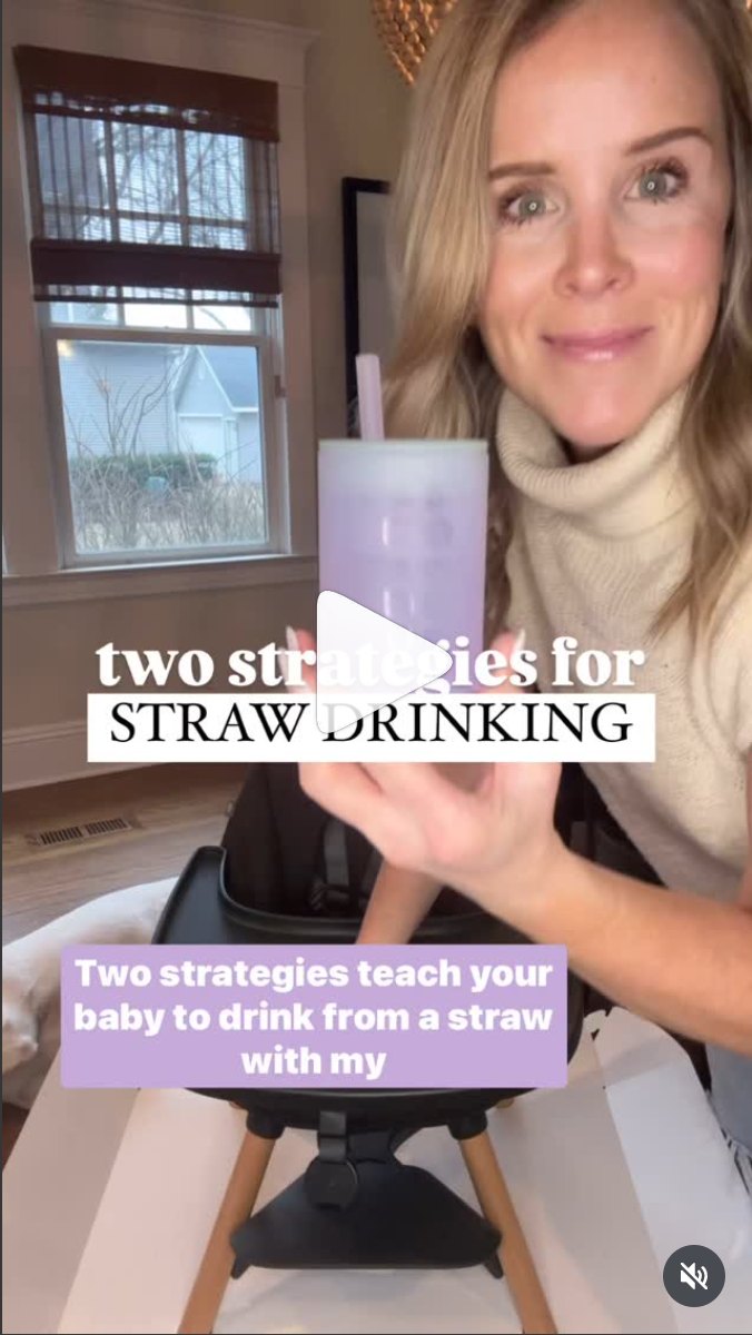 Video still: a woman holds up a lilac Olababy training cup with a straw beside a highchair. Overlay text reads "two strategies for straw drinking".